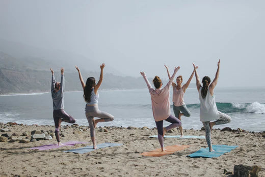 five ladies on beach doing yoga
