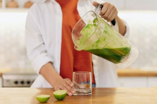 woman pouring smoothie into glass